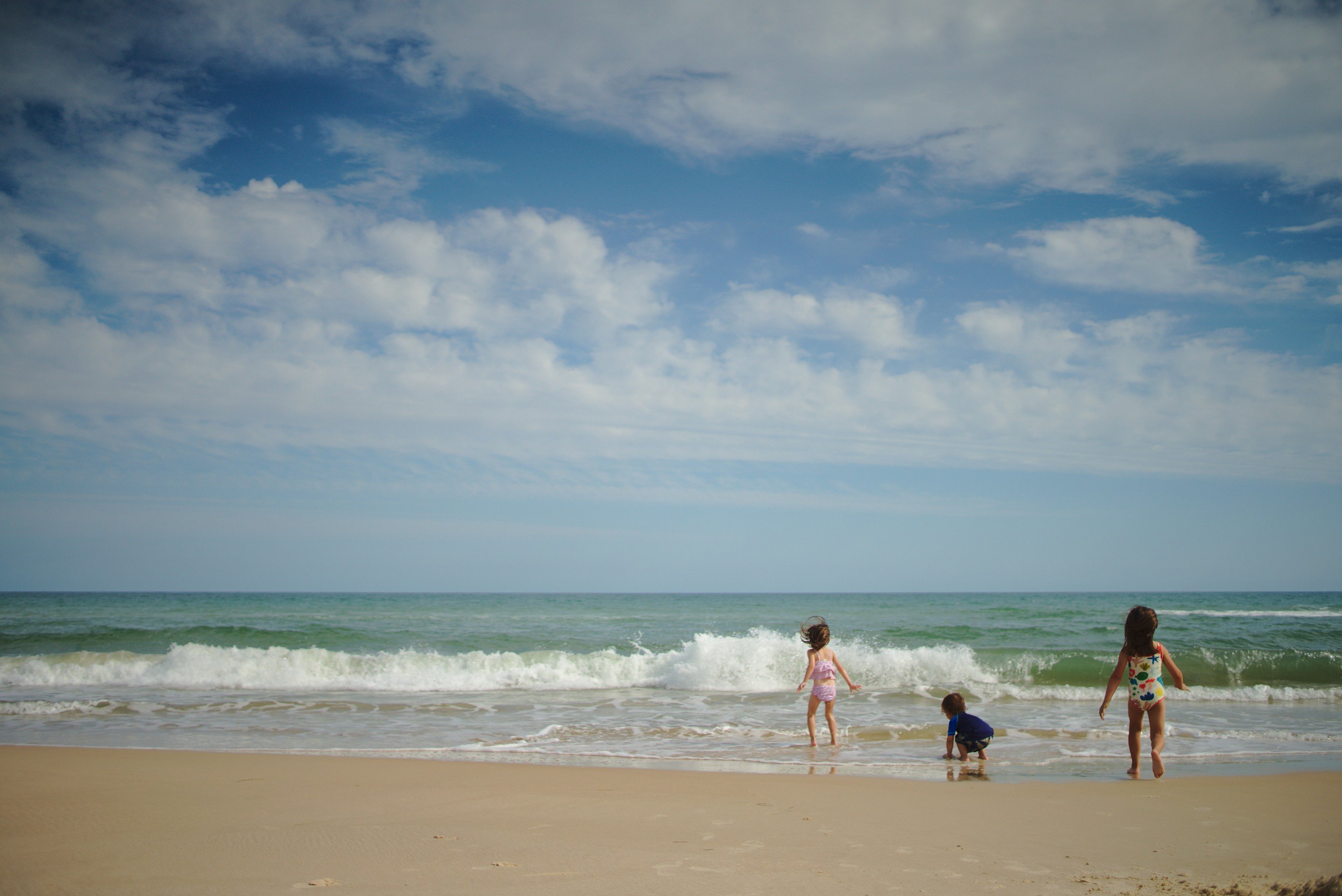 kids playing at beach photographed by luxagraf
