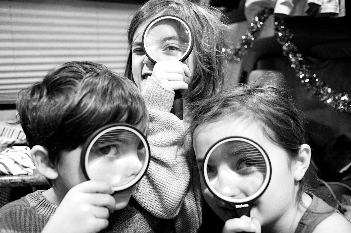 kids holding up magnifying glass photographed by luxagraf