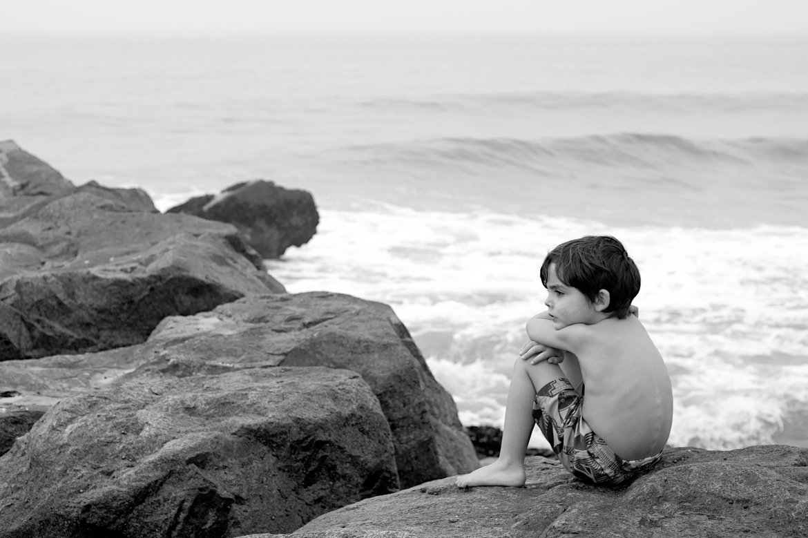 black and white photo of boy looking out at sea, newport beach, ca photographed by luxagraf