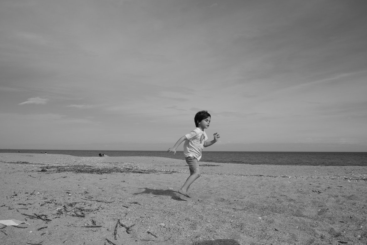 boy running on the beach, edisto state beach, sc photographed by luxagraf