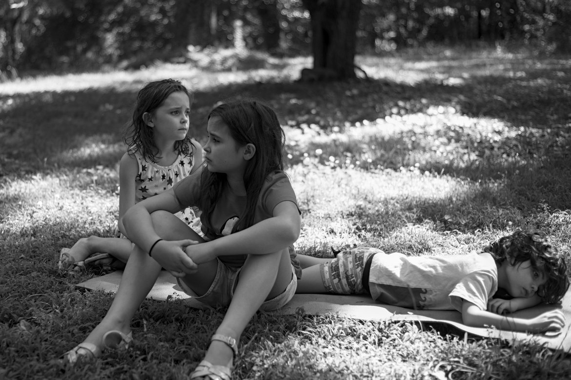 kids sitting the yard, looking gloomy photographed by luxagraf