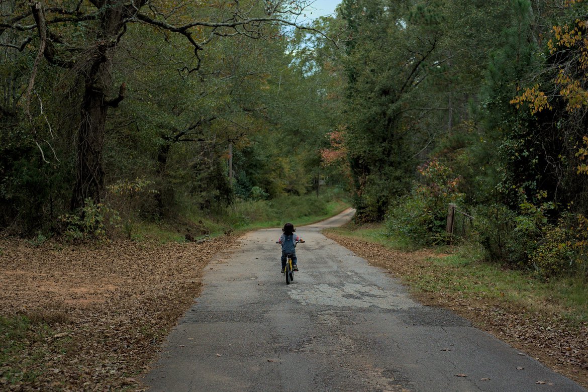 boy on a bike riding down the road. photographed by Scott Gilbertson