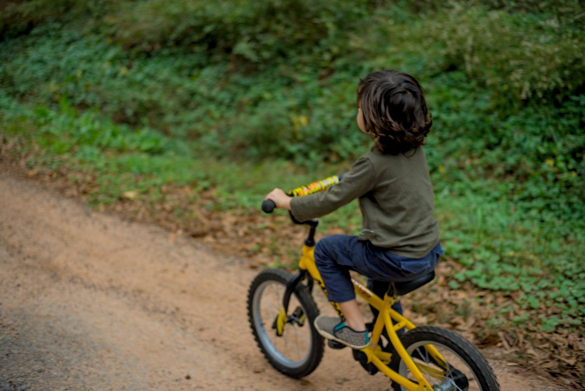 close up of a boy riding a bike photographed by luxagraf