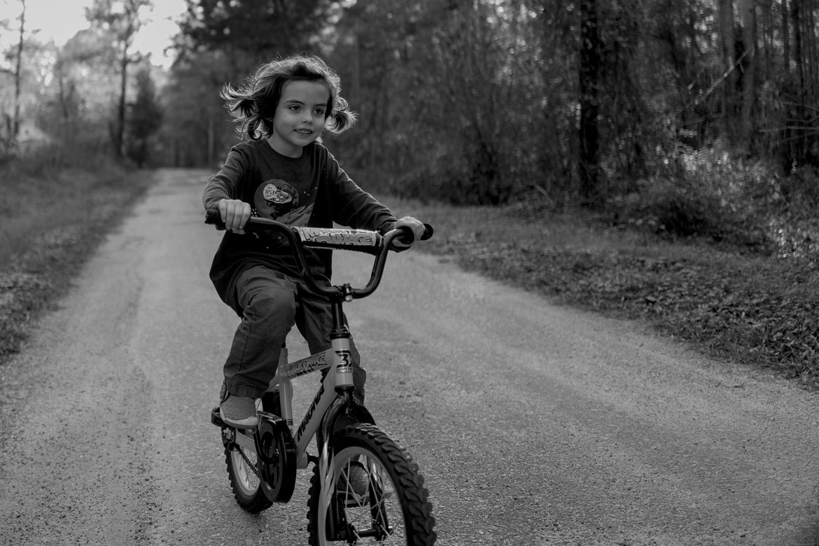 boy on a bike black and white photographed by luxagraf
