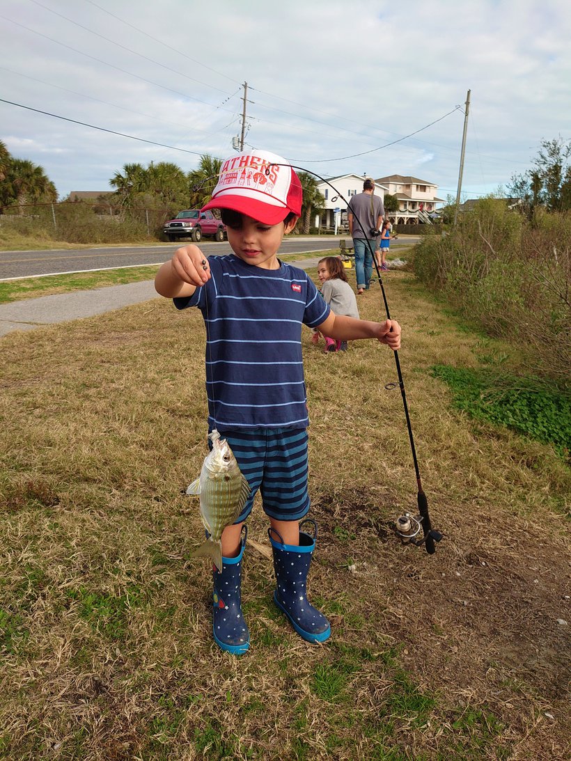 boy with a fish on the line photographed by luxagraf