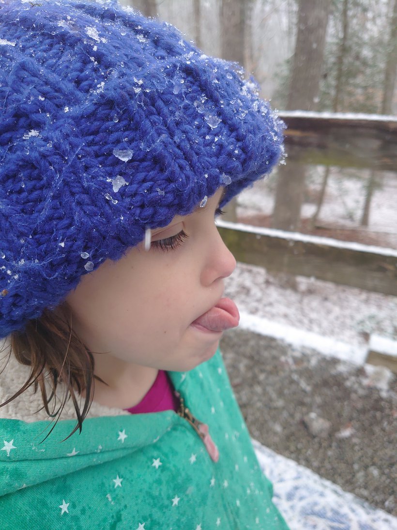 girl trying to catch snowflakes on her tongue photographed by luxagraf