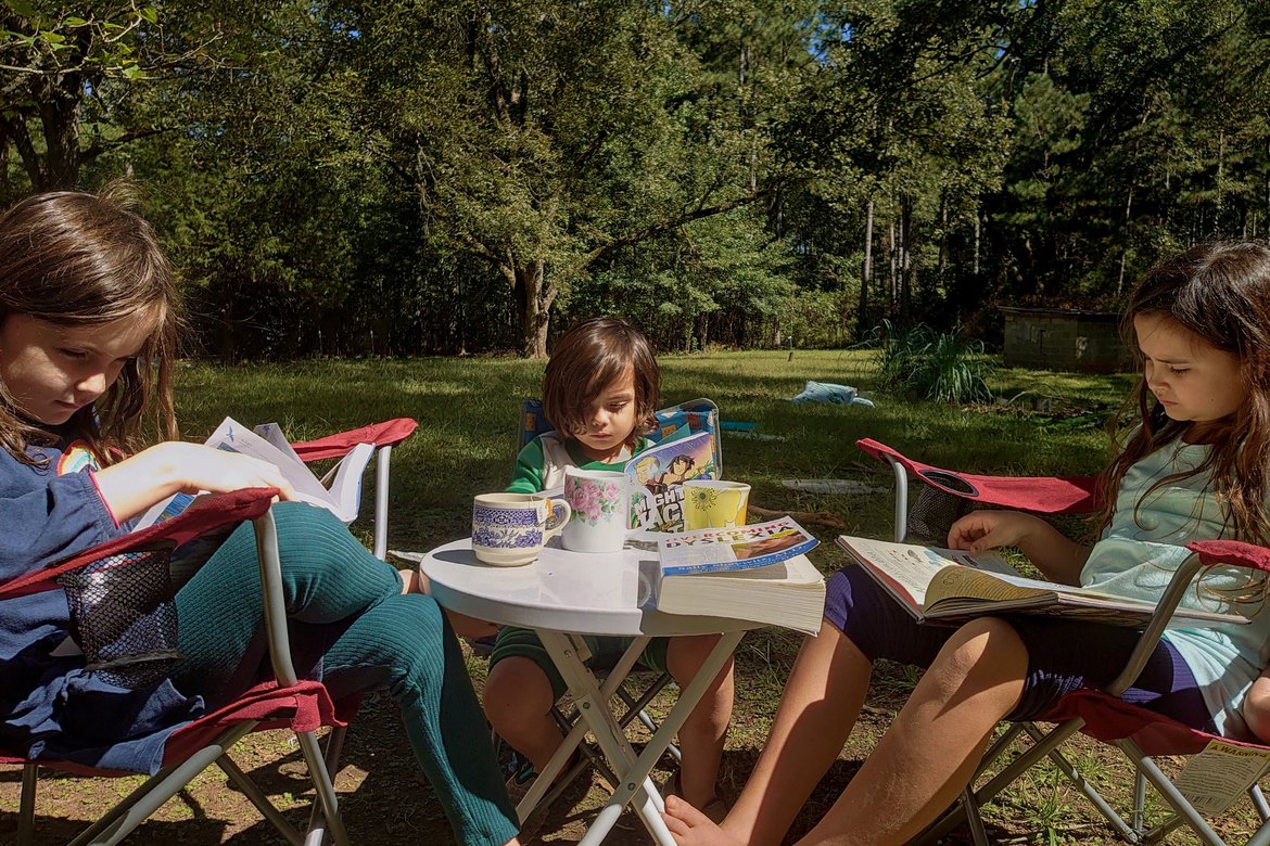 kids reading at a table outside photographed by Scott Gilbertson