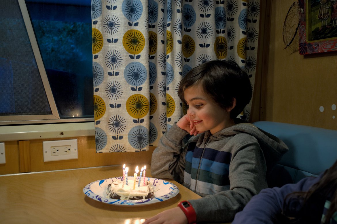 child with birthday cake and candles photographed by luxagraf