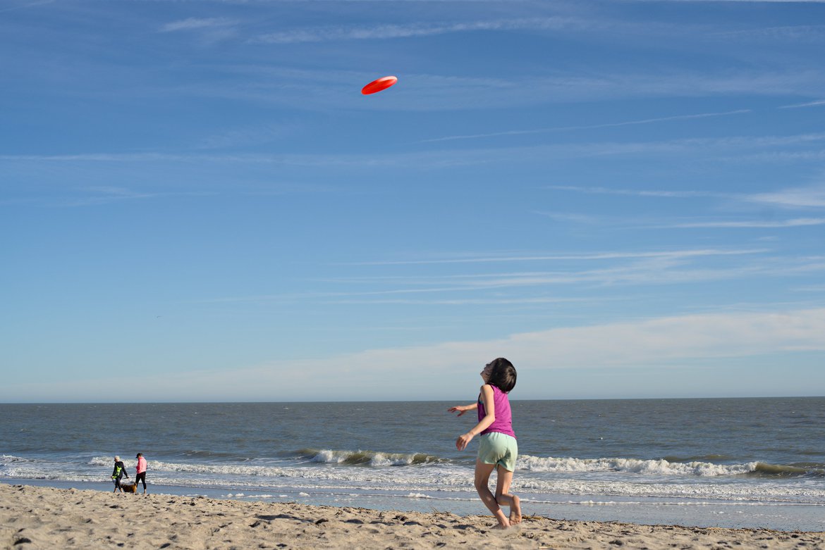 kids playing frisbee at the beach photographed by luxagraf