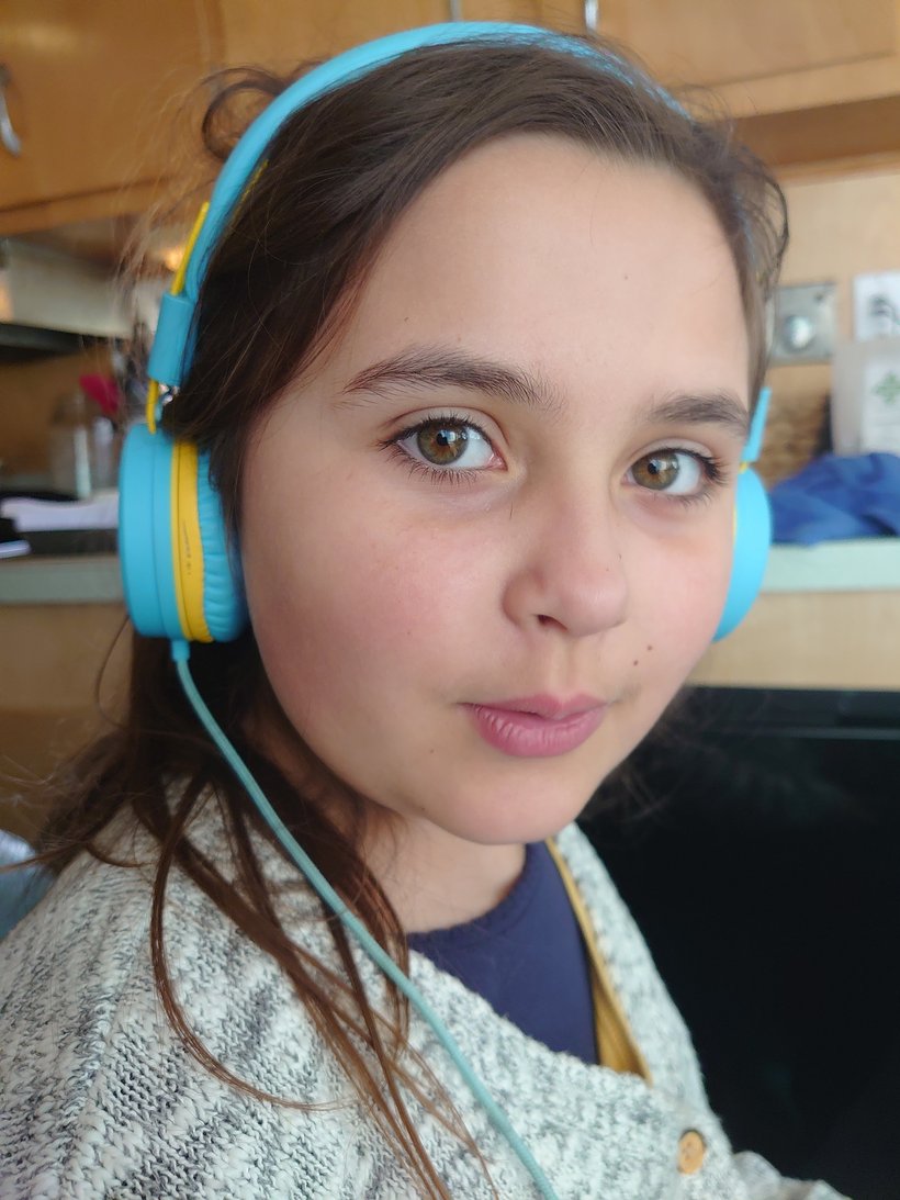 young girl listening to music on headphones photographed by luxagraf