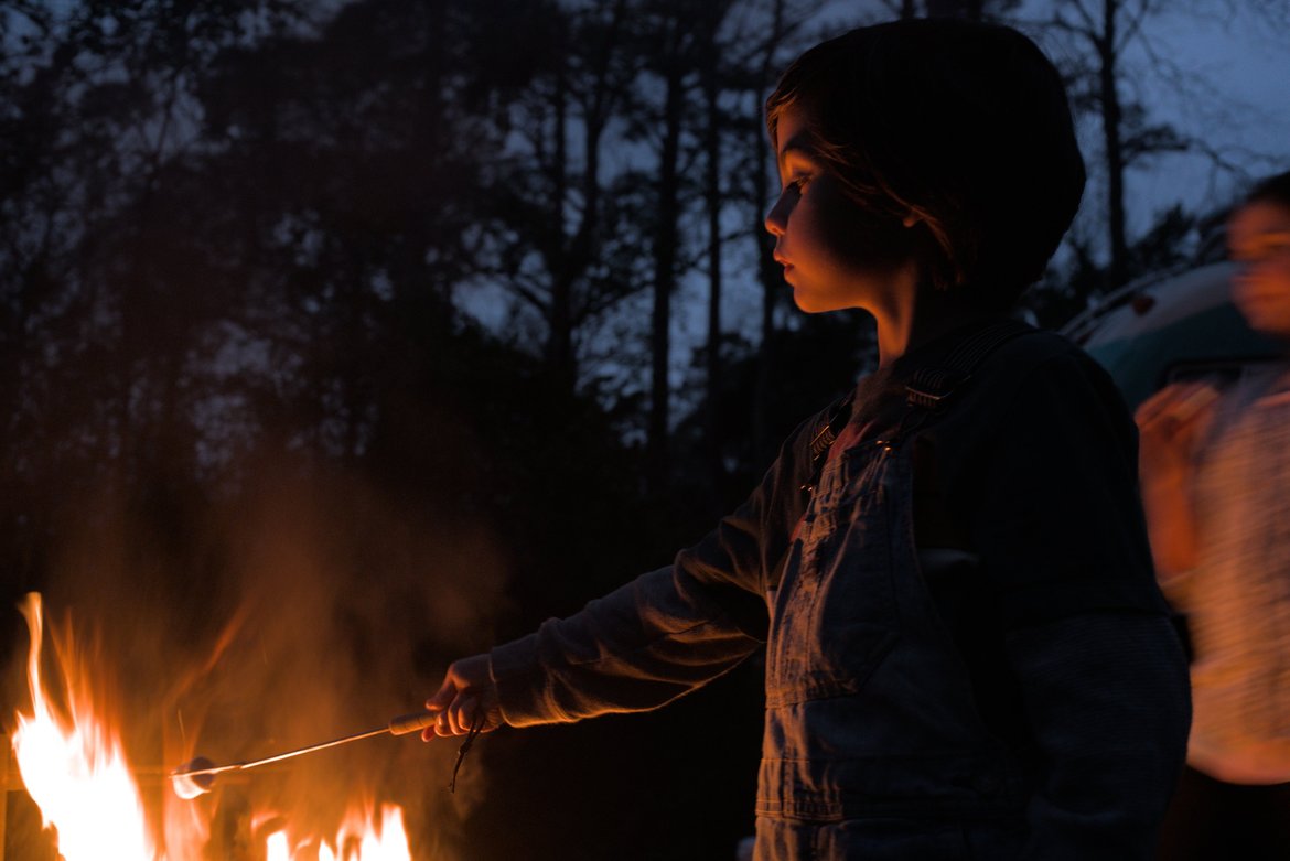 kids roasting marshmallows over a fire photographed by luxagraf