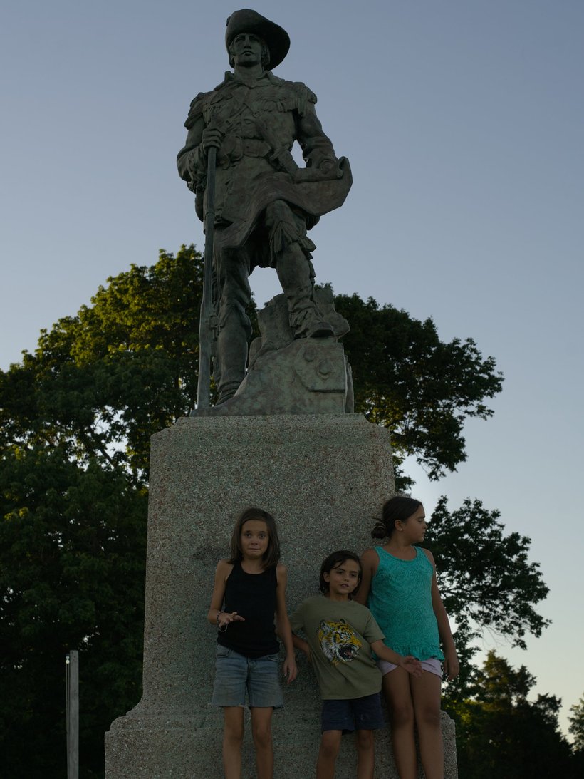kids standing beneath a statue of william clark photographed by luxagraf