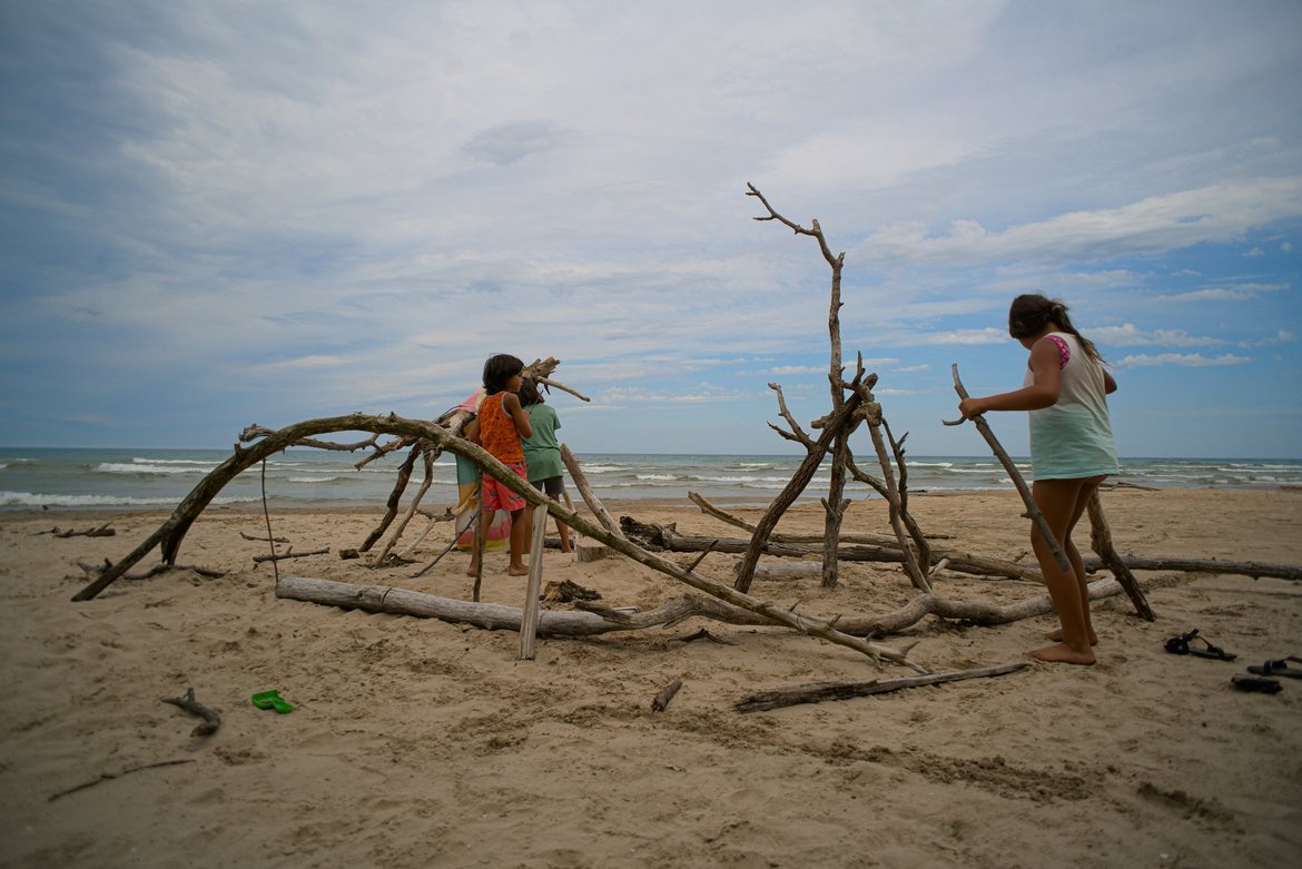 kids building a driftwood fort on the beach, harrington state park photographed by luxagraf