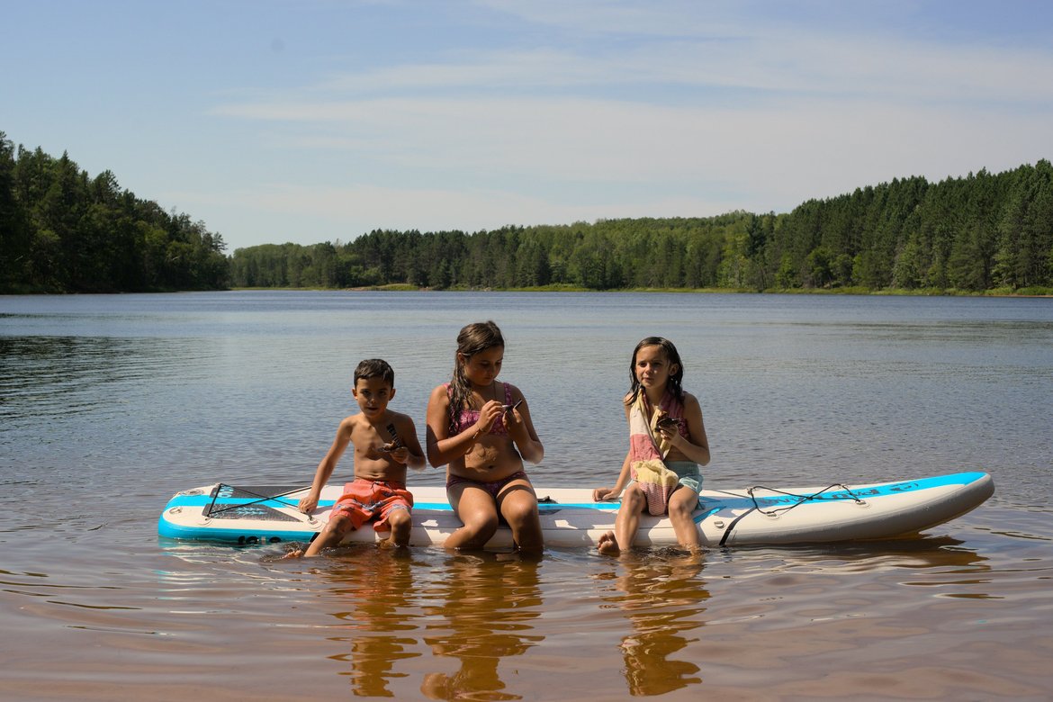 kids eating on a paddleboard, long lake, wisconsin photographed by luxagraf
