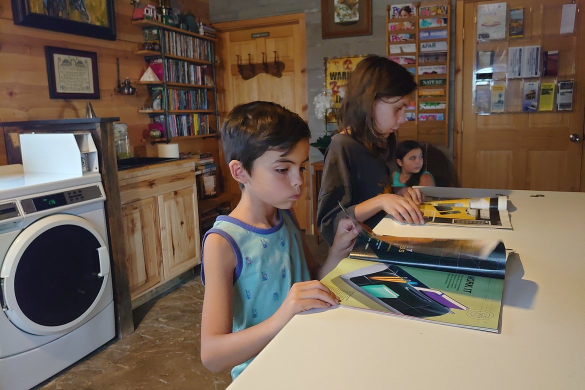 Kids reading WIRED magazines in the laundry room of the RV park photographed by luxagraf