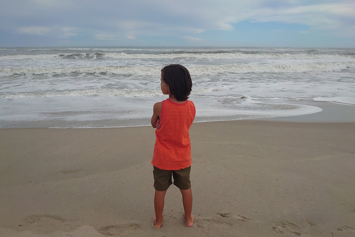 child staring out at the ocean photographed by luxagraf
