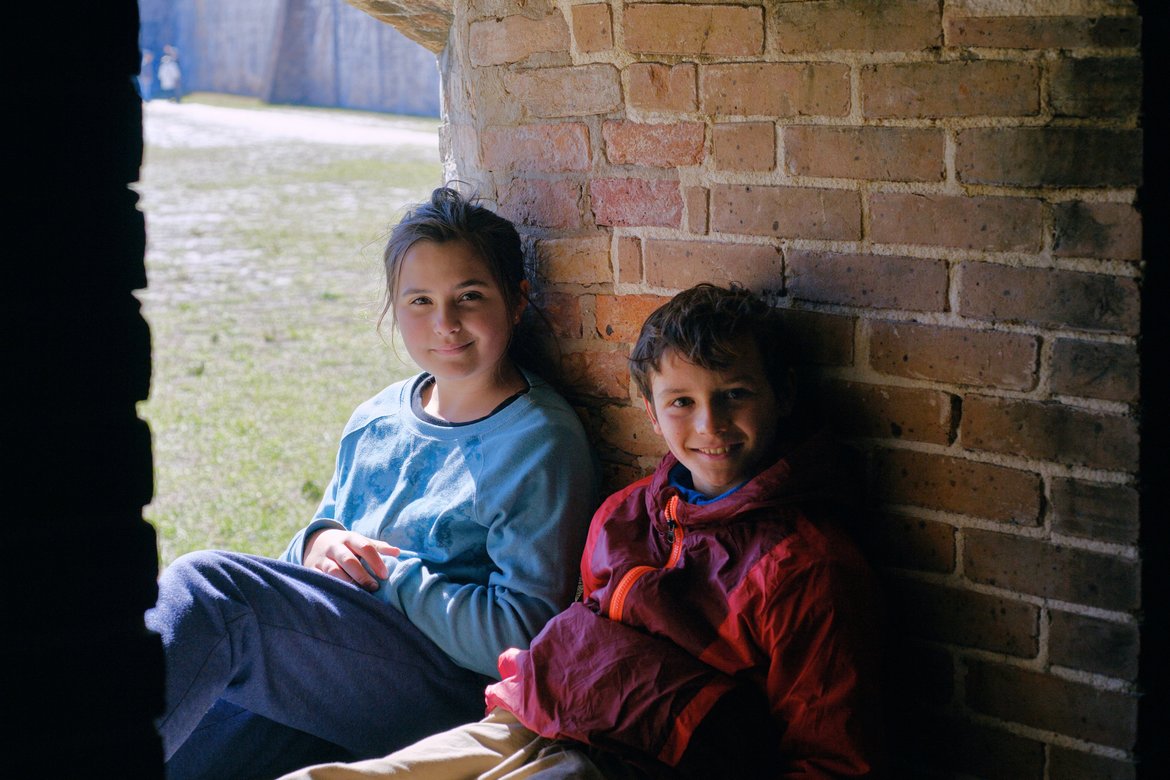 kids sitting in an arch of fort pickens photographed by luxagraf