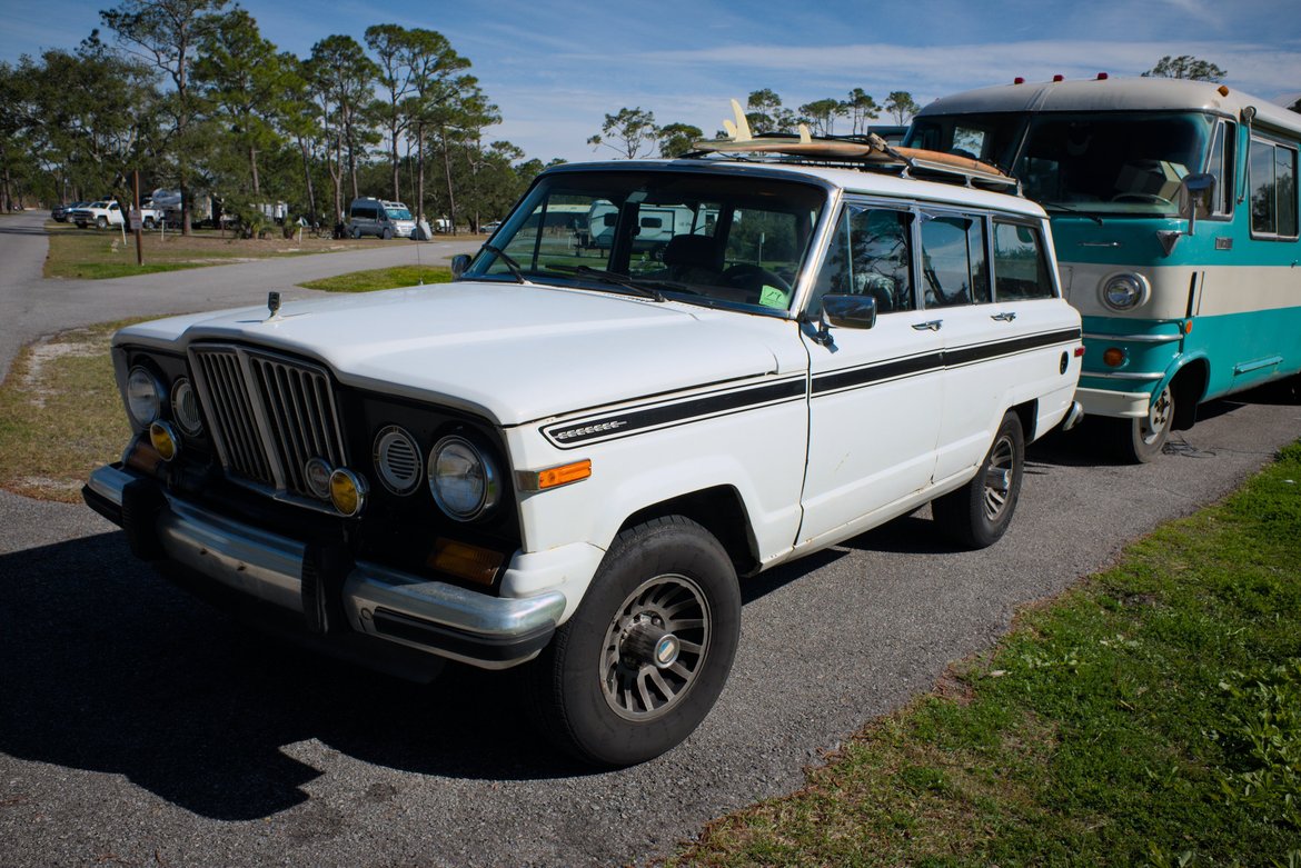 White 1989 Jeep Grand Wagoneer parked in front of a 1969 Dodge Travco photographed by luxagraf