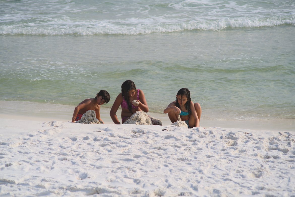 kids building a drip sandcastle on the beach, fort pickens, FL photographed by luxagraf