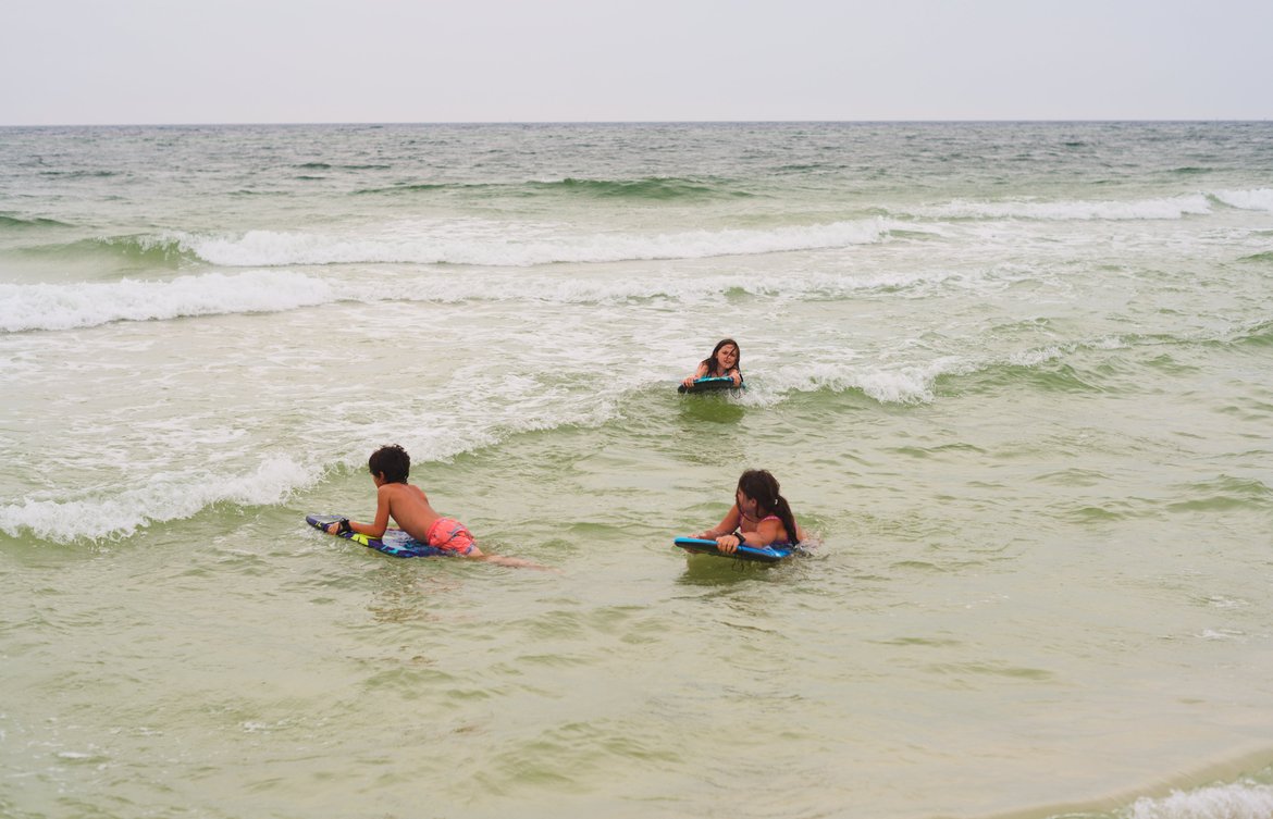 kids with boogie boards in the surf photographed by luxagraf