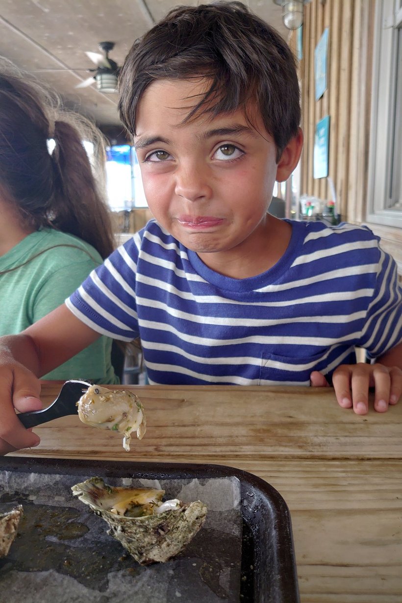 boy trying raw oysters photographed by luxagraf