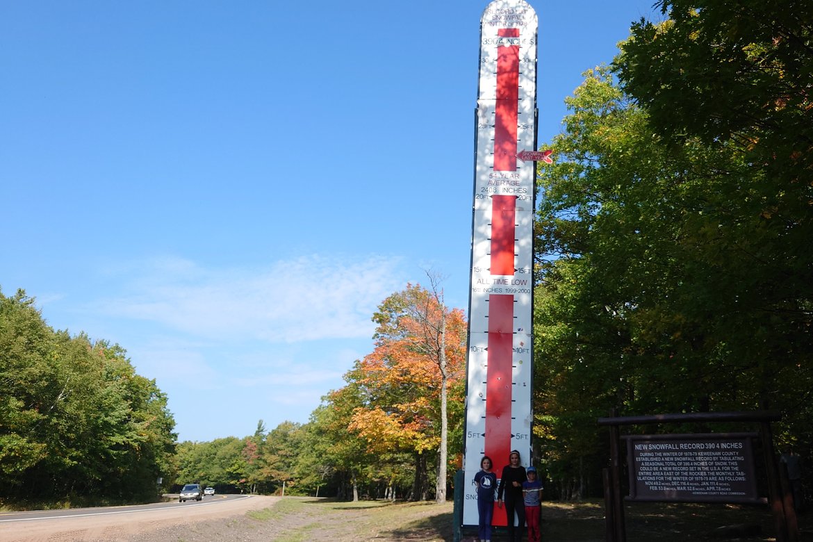 Snowfall height sign towering over children photographed by luxagraf