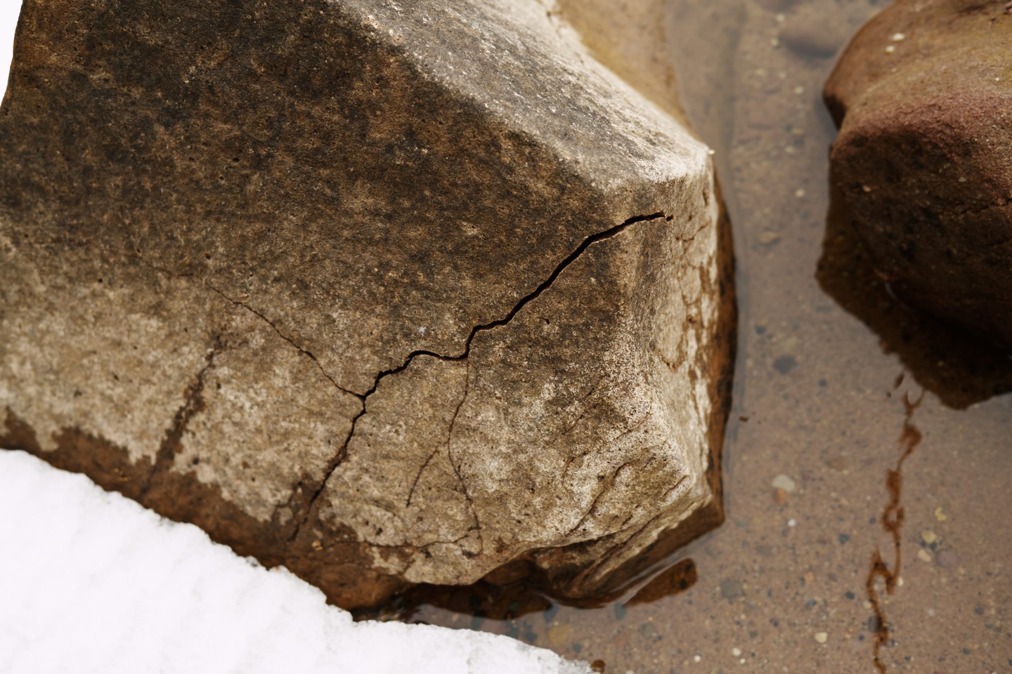 close up of a crack in a rock from winter ice by Scott Gilbertson