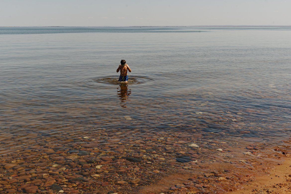boy dunking his head in the icy waters of lake superior photographed by Scott Gilbertson
