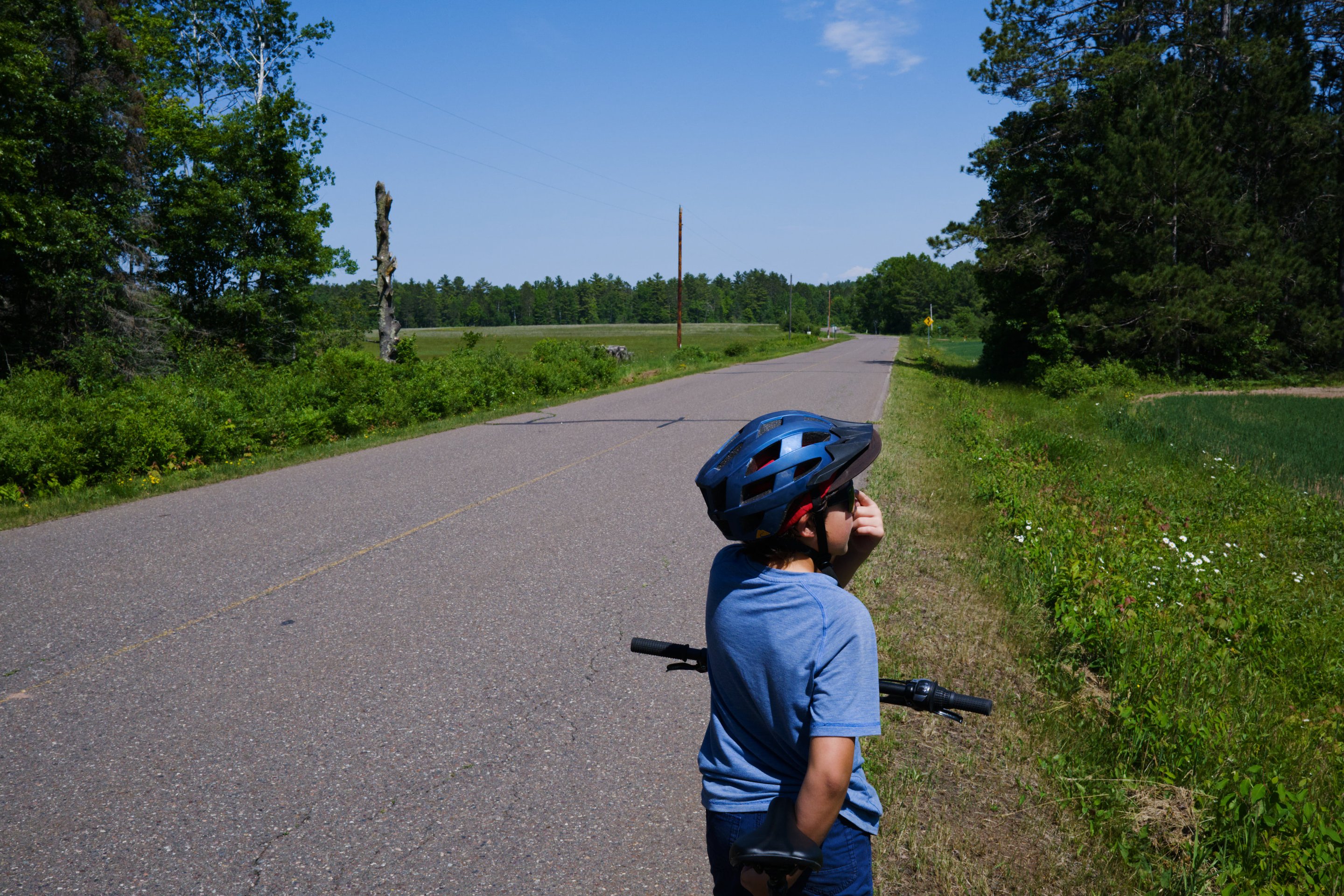 young boy riding on the side of the road photographed by Scott Gilbertson