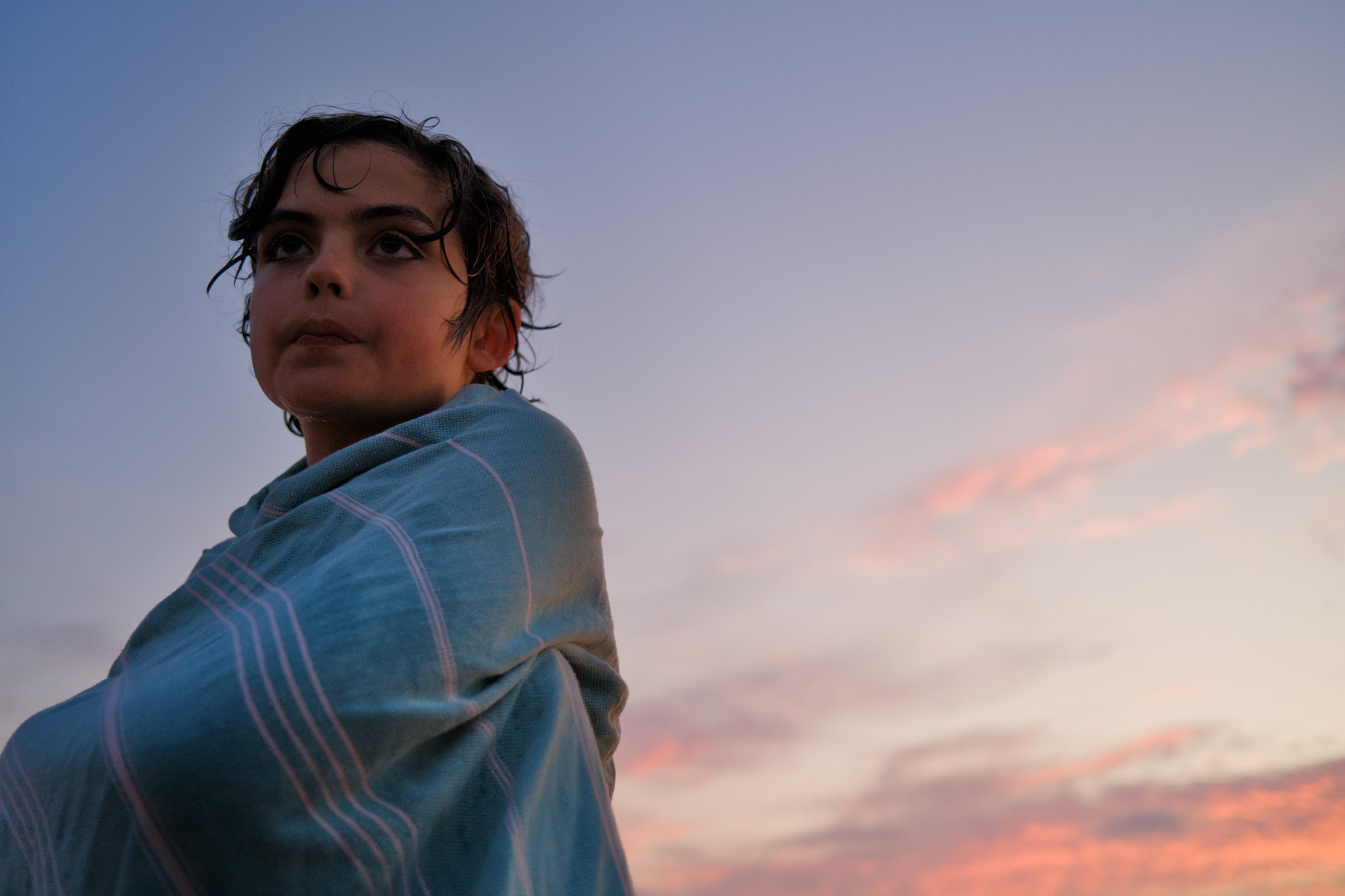 boy wrapped in a towel against the evening sky. photographed by Scott Gilbertson